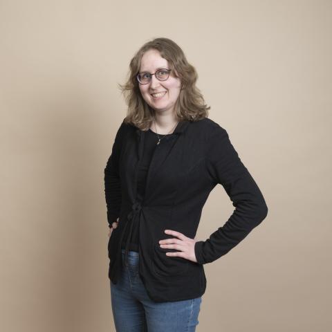 Profile picture of a blond woman with black jacket and jeans.