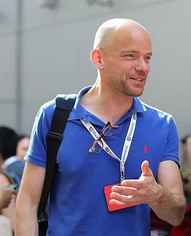 Foto of a bald man in a blue shirt