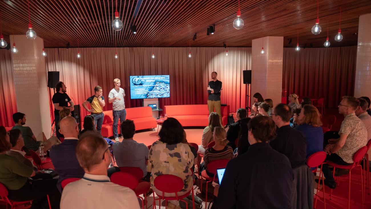 The same three young man holding a presentation before a room of people