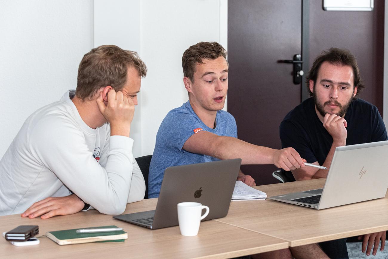 Group of three young man discussing